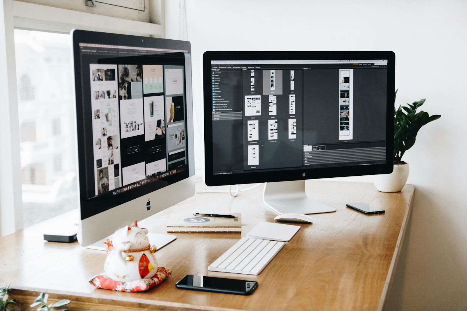 Two iMacs With Keyboard and Phones on Desk