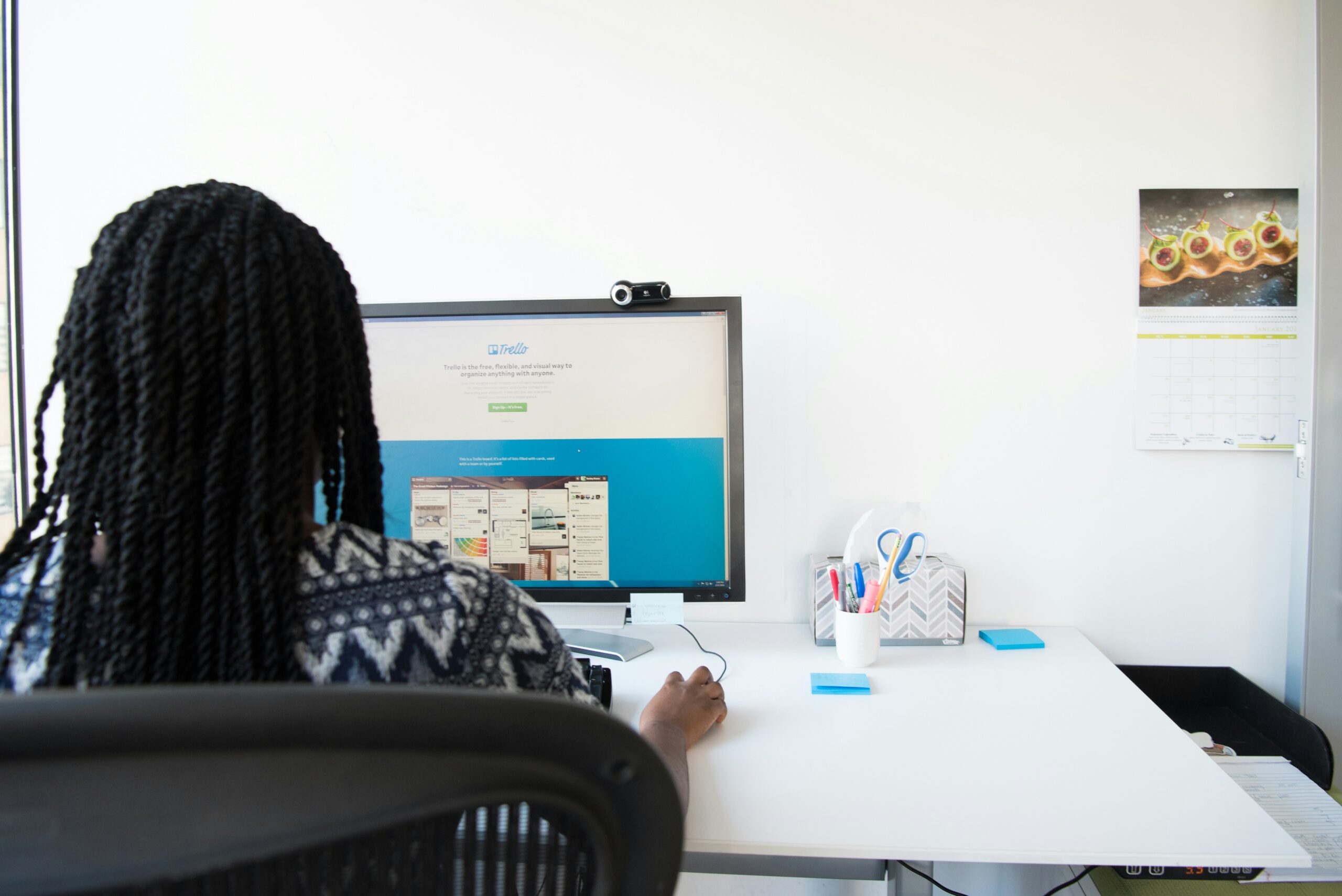 A female employee browsing the Trello website on her monitor