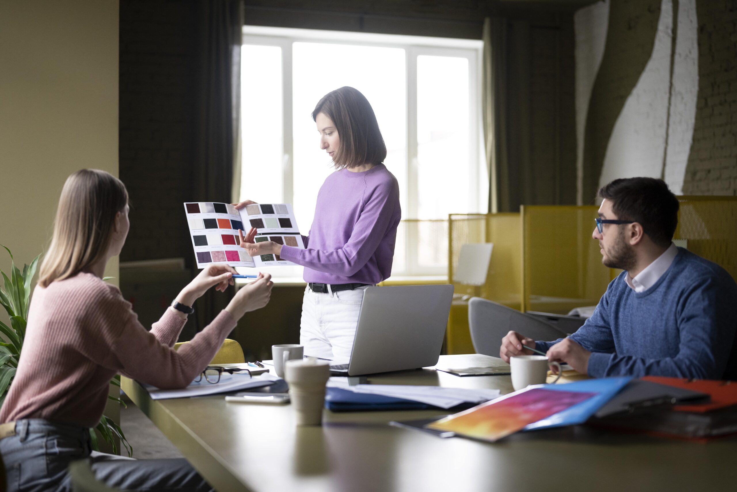Team discussing color palettes during a creative strategy meeting in a modern office.