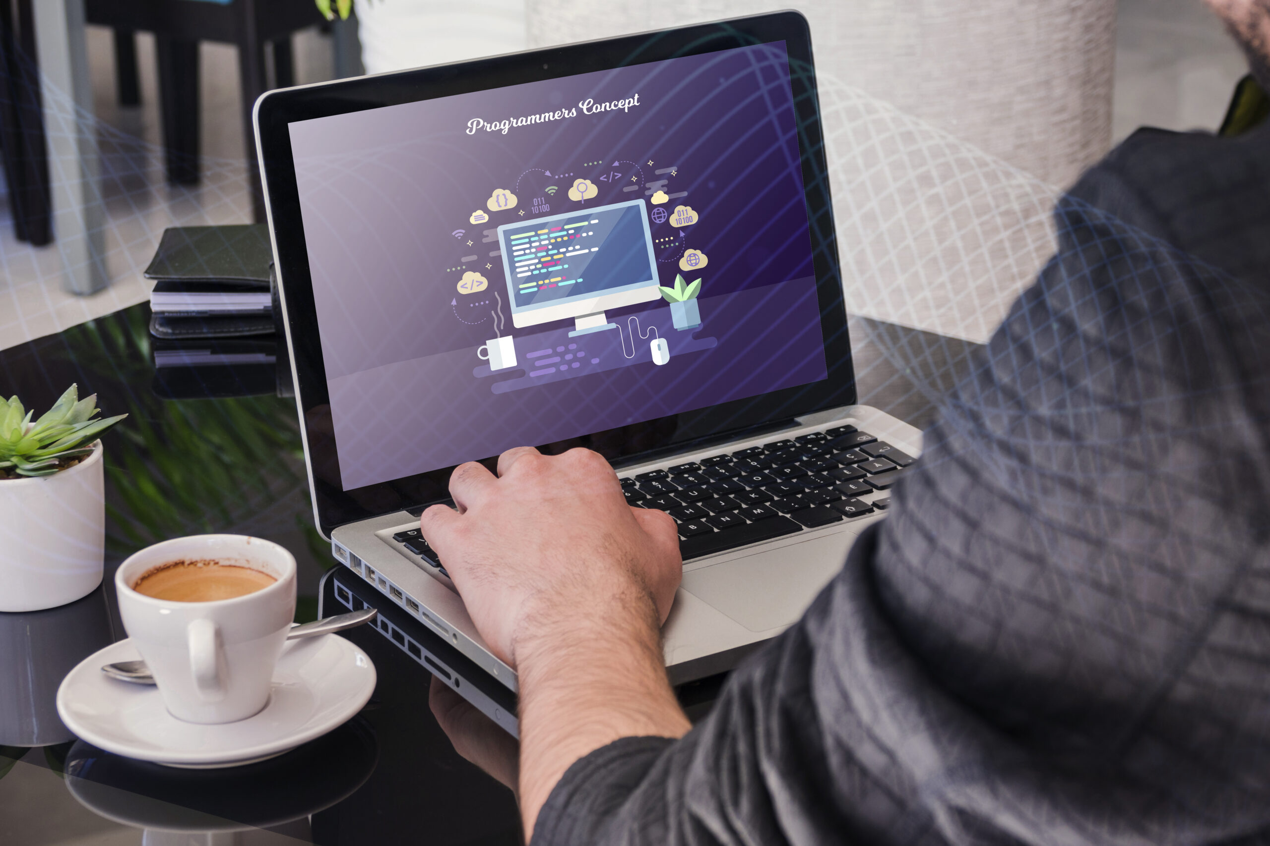 A developer working on a laptop with a programming concept displayed on the screen