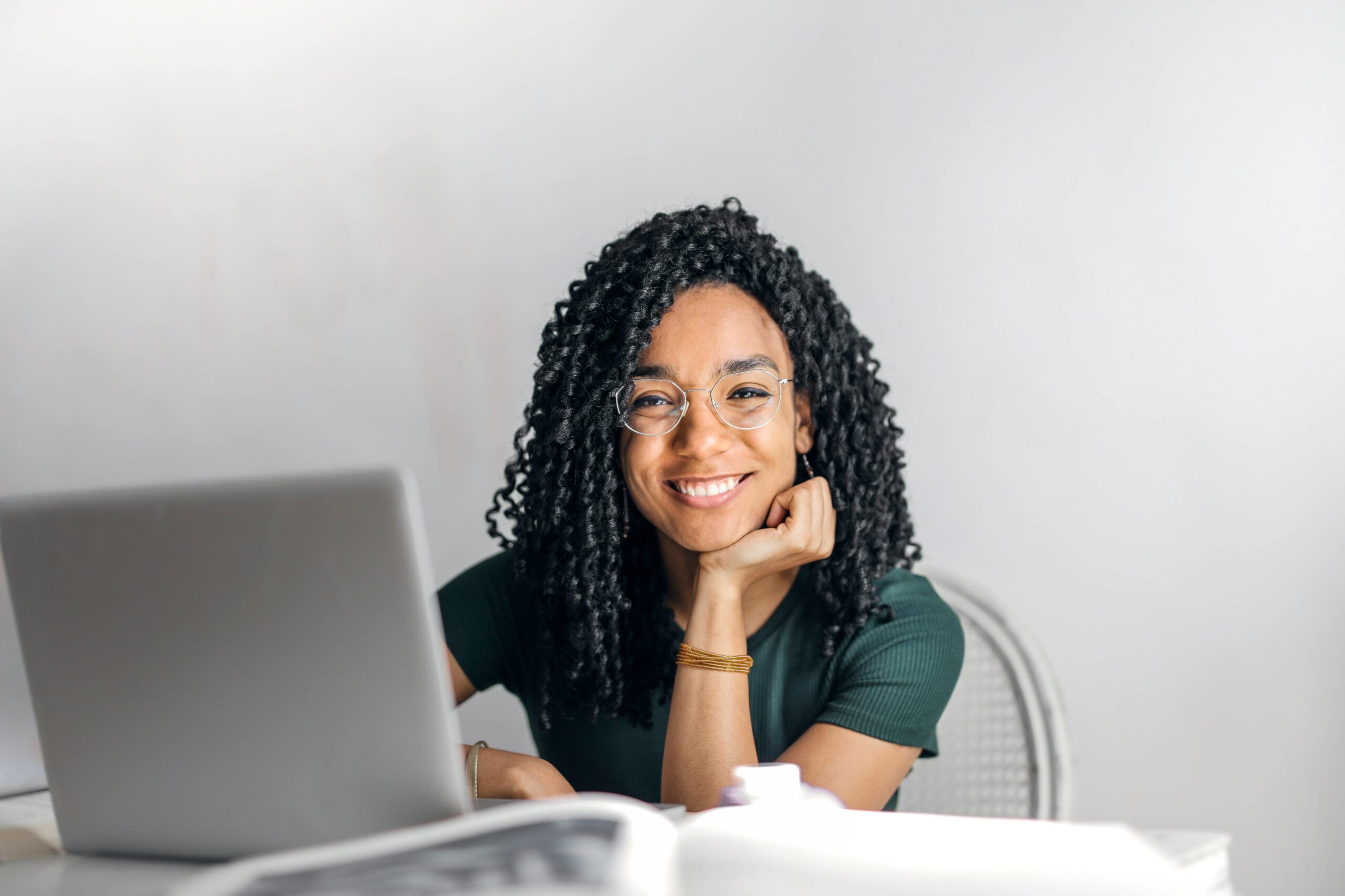 a woman smiling while using a laptop